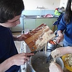 Der Teig wird mir raschen Bewegungen in das kochende Wasser geschabt