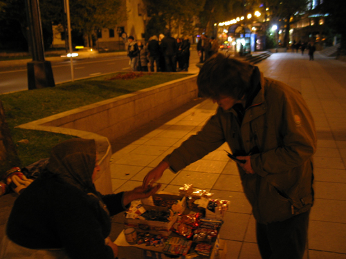 Pascal kauft sich ein Feuerzeug bei einer Straßenhändlerin.