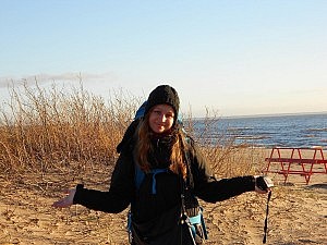Mit Mütze und Reiserucksack am Strand