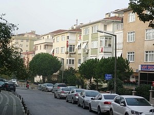 Über den Balkonen oder aus den Fenstern hängen die Fahnen.